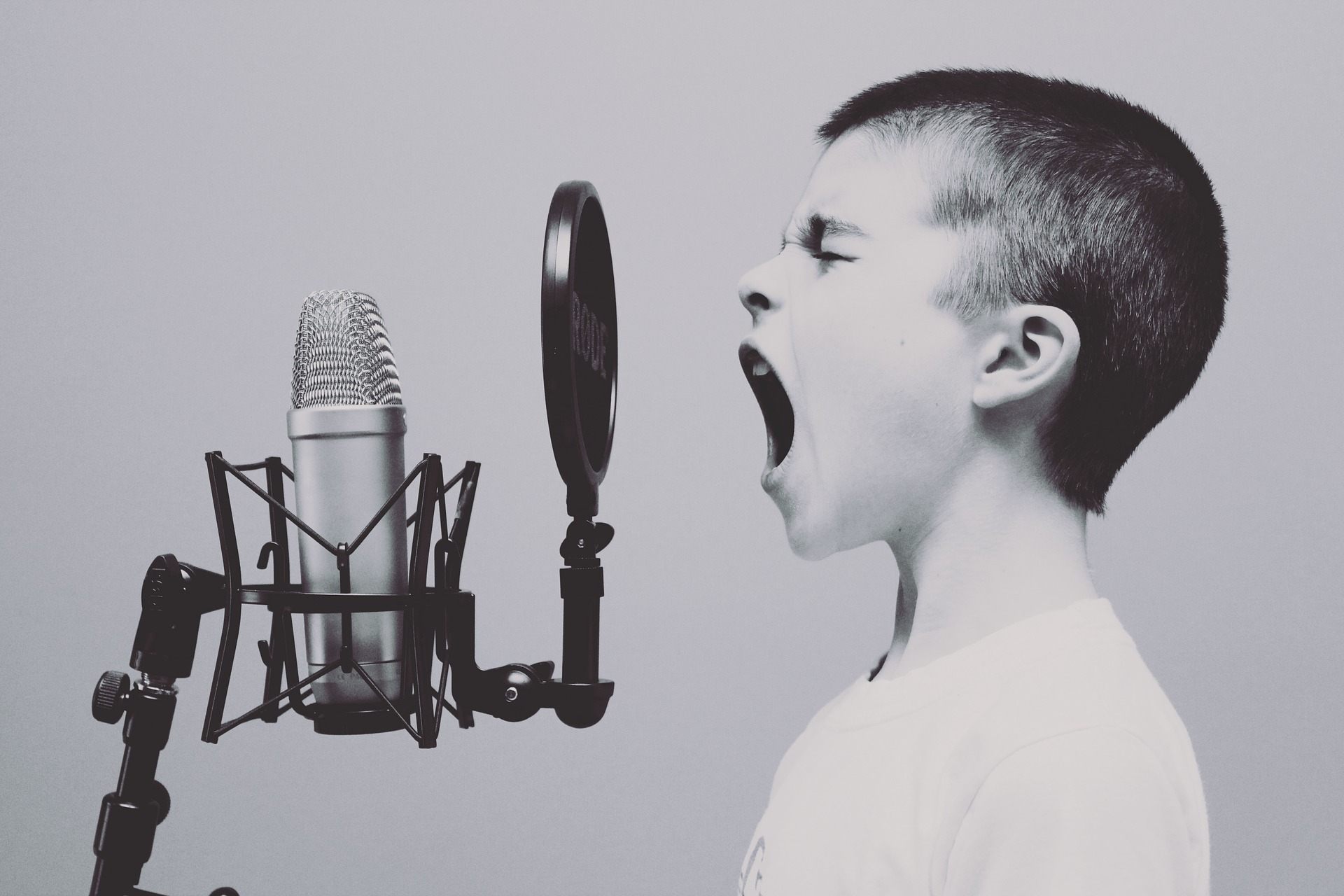 Ein Kind singt vor einem Studiomikrofon